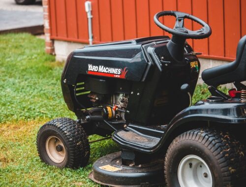 Riding lawn mower positioned on a residential lawn for efficient grass cutting.